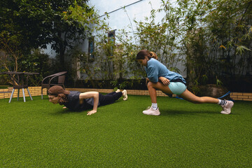 Obraz premium Young adults exercising outdoors on grass in urban backyard with push-ups and lunges