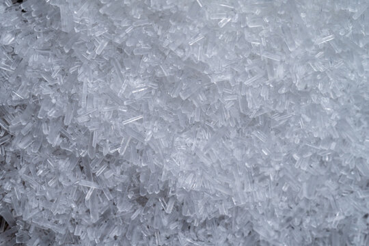 Detailed macro texture of white monosodium glutamate crystals. Pure MSG seasoning background for food science and culinary industry concepts.