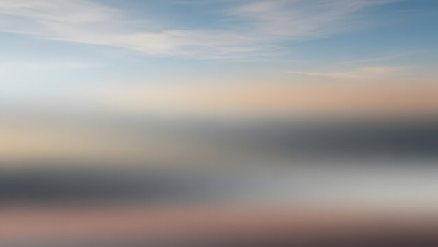 Soft blurred background featuring a gradient of blue sky and warm sunset tones over a hazy horizon