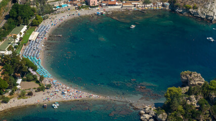 Aerial view of the beach of Isola Bella, in Sicily, Italy. It is a small bay with crystal-clear...