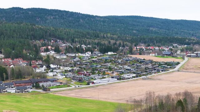 residential neighborhoods spread across forested hillside panorama winding roads link modern homes norway aerials forest wide drone nordic landscape 
