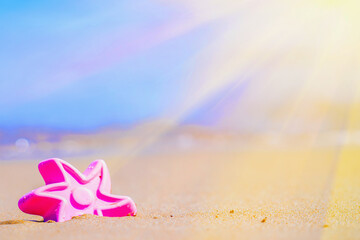 Minimalist summer beach scene featuring a pink starfish on sand and pastel ocean background.