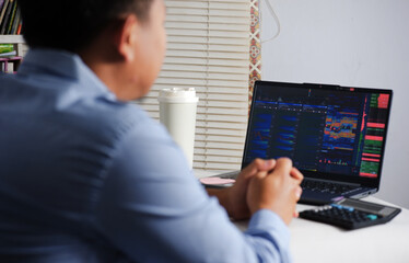 Looking at computer monitor screen and thinking analyzing stock market and bitcoin. tense expression waiting for growth and stock movement. Businessman Analyzes Sales Statistics and Graphs Displayed o