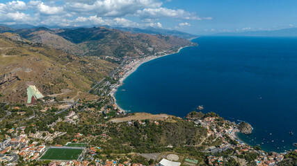 Obraz premium Aerial view of the long beach of Letojanni, in the province of Messina, Sicily, Italy. It's the eastern coast of Sicily, overlooking the Ionian Sea. The Nebrodi Mountains are to the side.