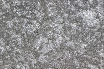 Frozen water and water crystals of various shapes. Gray background. Top view.