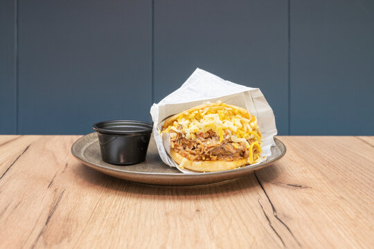 the arepa is a versatile, round plate, whether filled with Venezuelan perico (scrambled eggs with tomato and onion) or a stew of shredded beef.