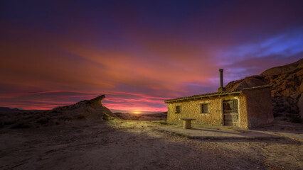 Abandoned ruined hut in Bardenas Reales desert under a moody twilight sky with long exposure
