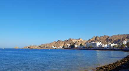 Mutrah Corniche in Muscat, Oman, and Al Hajar mountains seen in the distance. Scenic cityscape with copy space