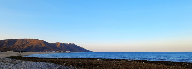 Sunset on Al Sifah beach not far from Muscat, Oman. Web banner with copy space