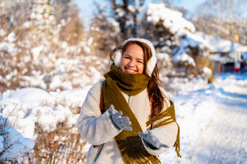 Winter portrait of happy young woman in warm clothes outdoors