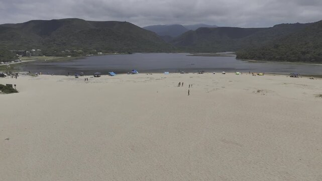 Drone flies north from sea over Otter Trail and up Groot River on a sunny day in Nature's Valley, South Africa