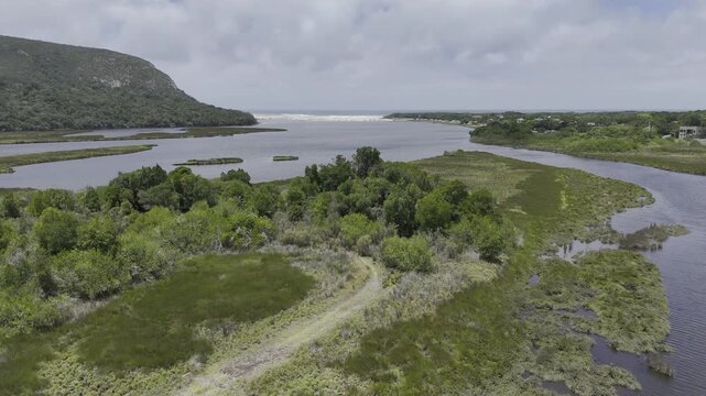 Drone flies south along Groot River toward the sea on a sunny day in Nature's Valley, South Africa