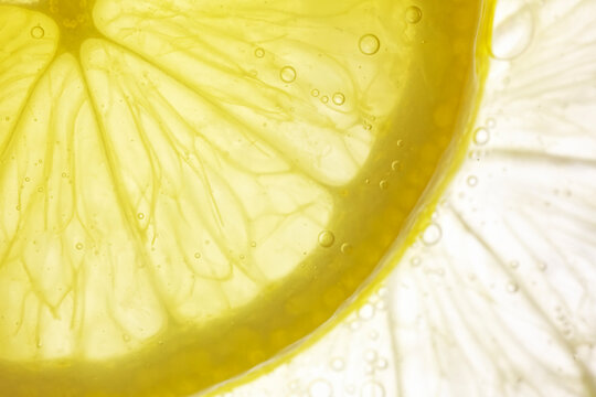 Lemon or lime in sparkle water drops vitamin c cosmetic background for beauty product swatch