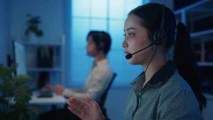 Closeup Gen z Asia young call center team or customer support service executive use computer and microphone headset work technical e commerce in late night office. Telemarketing or sales job concept. - Powered by Adobe