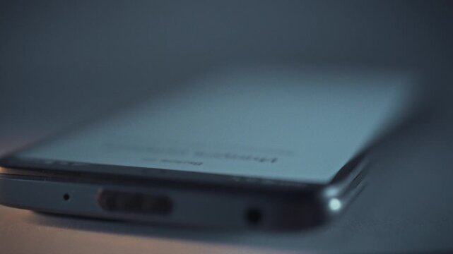 In darkness of night, smartphone screen illuminates, signaling incoming call. sudden ring tone breaks silence, announcing notification on the device, as the phone springs to life amidst the stillness