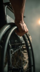 Strong hand propels wheelchair wheel forward with determination