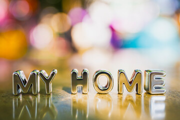 Metallic letters spelling My Home with colorful bokeh background, symbolizing comfort, belonging,...