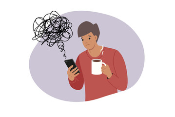 Man reads news on mobile phone, causing deterioration in mood and chaos in thoughts. Guy with mug of coffee and smartphone became victim of misinformation and propaganda on news sites.