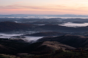 Gradina viewpoint at mountain Zlatibor offering beautiful view of hilly rural landscape and valleys filled with fog at dawn, visit Serbia countryside, autumn season at October