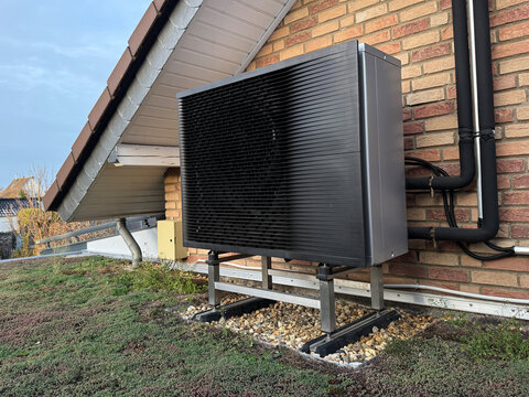 Luft-Wasser-W&auml;rmepumpe op Gr&uuml;ndach vor einer Klinkerfassade