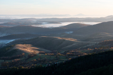 Gradina viewpoint at mountain Zlatibor offering beautiful view of hilly rural landscape and valleys filled with fog at morning first rays of light, visit Serbia countryside, autumn season at October