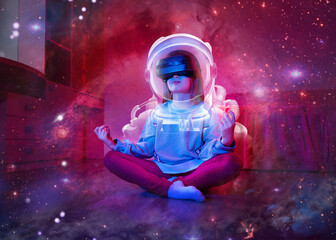 Child girl wearing virtual reality headset like as astronaut and looking at digital space system. Space exploration with augmented reality glasses. Kid is sitting on flor at childroom.