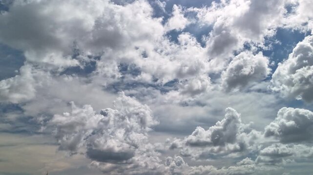 Time lapse of cumulus clouds evolving into cumulonimbus showing strong convection vertical growth and anvil shapes signaling changing weather and approaching thundershowers
