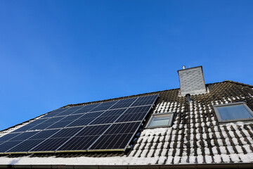 Solar panels generating clean energy on snowy roof