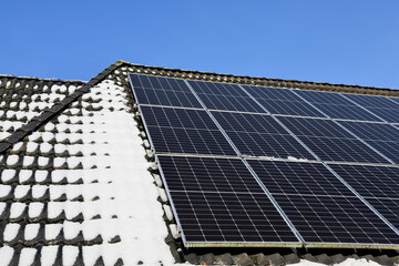 Solar panels generating clean energy on snowy roof