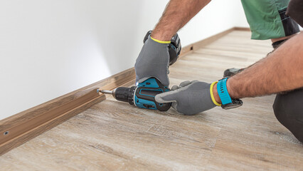 Installing elegant plastic baseboard, showcasing skilled craftsmanship in home improvement and...