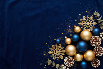 A collection of gold Christmas ornaments artfully arranged on a dark blue background, creating an elegant and festive atmosphere