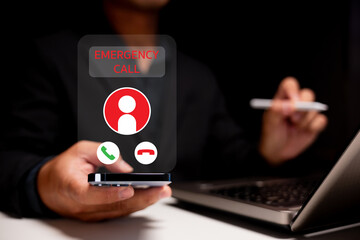 A person receives an emergency call on a smartphone while using a laptop, emphasizing the importance of communication in urgent situations.