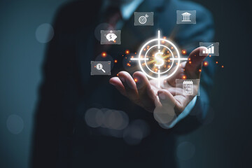 Businessman Holding Digital Financial Target and Currency dollar Icons. Businessman in a suit holding hand out as various illuminated digital icons related finance, strategy, and success float above.