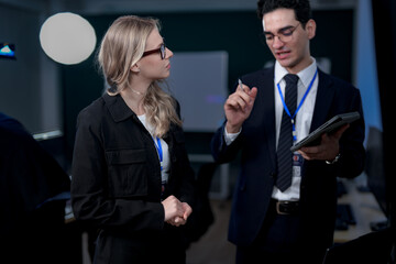 A diverse and dedicated team of professionals works diligently in a bustling, modern tech office at night, collaborating and focusing on their tasks to meet a critical project deadline.