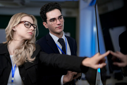 A quantum computing scientist explains a complex algorithm to a colleague, pointing to the code that will run on a quantum processor to solve a problem previously thought impossible.
