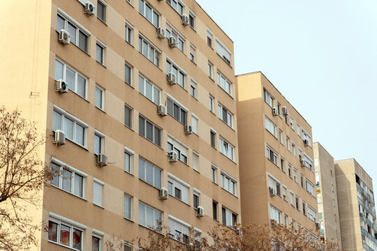 Building with multiple windows and air conditioning units in a city on a clear day