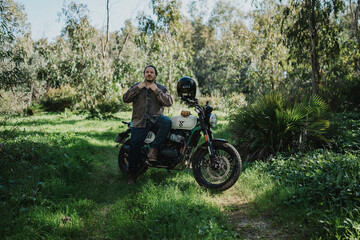Fototapeta premium Hombre aventurero con barba en moto estilo scrambler en el bosque en dia soleado