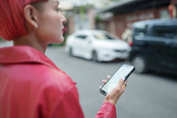 Traveler Gen z girl leather fashion with punk Asian woman tourist in city street searching location in map application online smart phone using GPS navigating