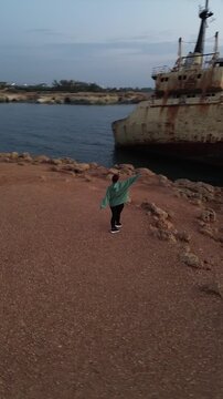 women and old rusty sheap on the background