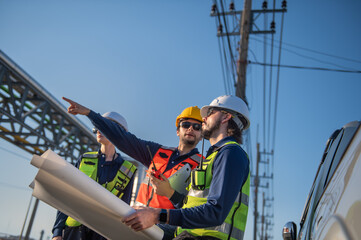 Engineers Reviewing Construction Plans at Industrial Gas Storage Facility, Industrial engineer inspecting petrochemical facility construction blueprint at gas storage plant site.