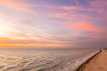 Obraz premium Sunset beach with gentle waves and colorful sky