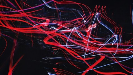 Vibrant red and blue light trails dancing in the dark, creating a mesmerizing display of energy and motion