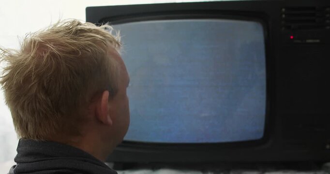 Close view of person hypnotized by static screen of old CRT TV. Screen hypnosis and visual fixation concept