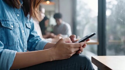 Young woman's hands skillfully operating her smartphone, engaging with digital content in a contemporary urban cafe setting, highlighting modern connectivity and personal leisure - Powered by Adobe