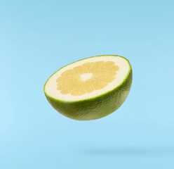Fresh ripe green sweetie falling in the air isolated on blue background