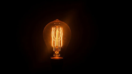 A glowing light bulb shines brightly in a dark room