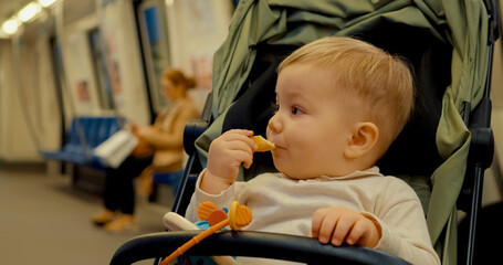 Young mother shares bread with her baby on a subway journey in the city
