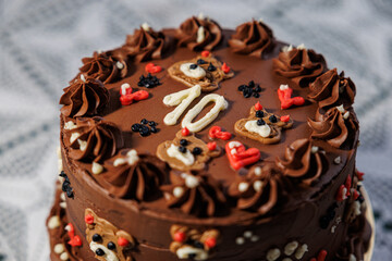 Rich chocolate cake with piped buttercream, teddy bear motifs, hearts, and a bold number ten, displayed on a lace-covered table as a festive celebration centerpiece