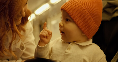 Mother and baby share a quiet moment on the subway during their journey