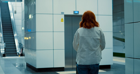 Young mother with baby stroller approaches subway elevator in city